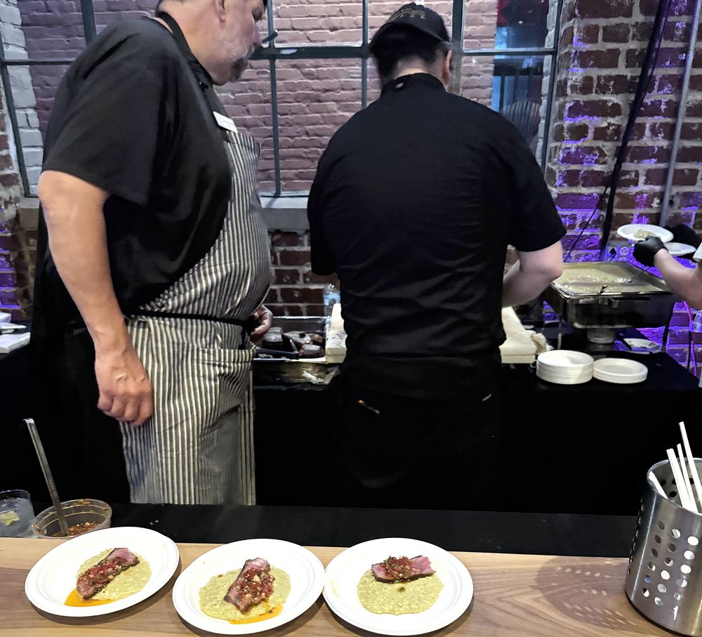 Chefs plating dishes at a gala chef station
