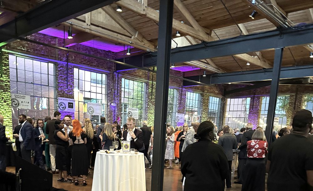 Guests filling a brick-and-steel warehouse venue during a fundraising gala